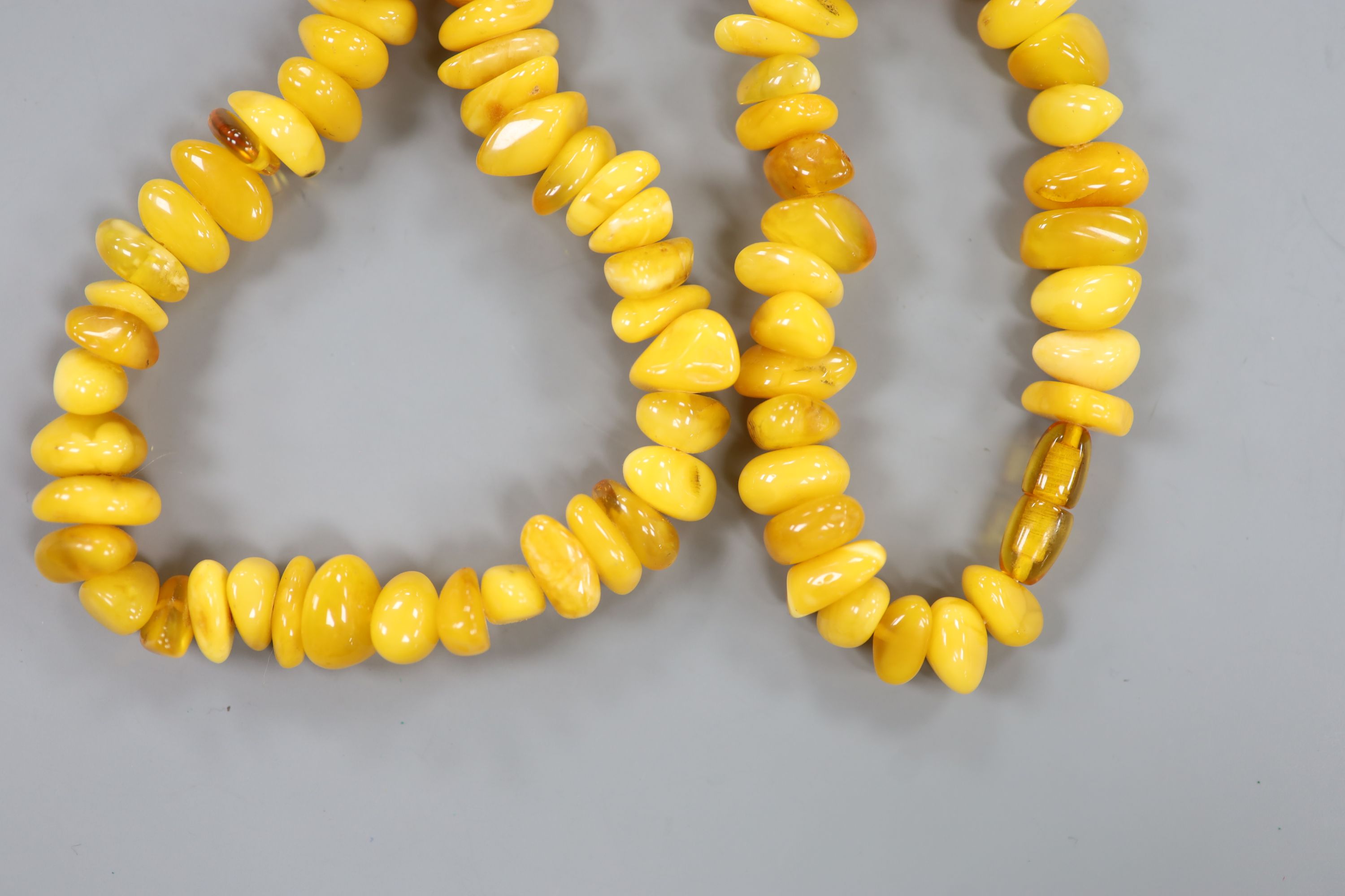 A single strand amber pebble necklace, approximately 66cm, gross weight 75 grams.